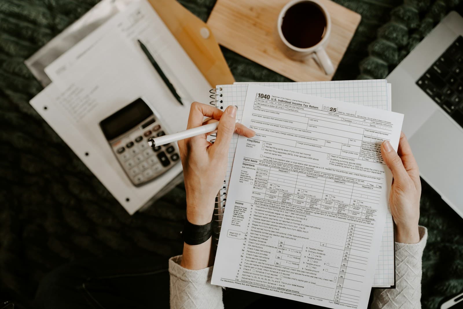 Finance professional reviewing reports with laptop and calculator