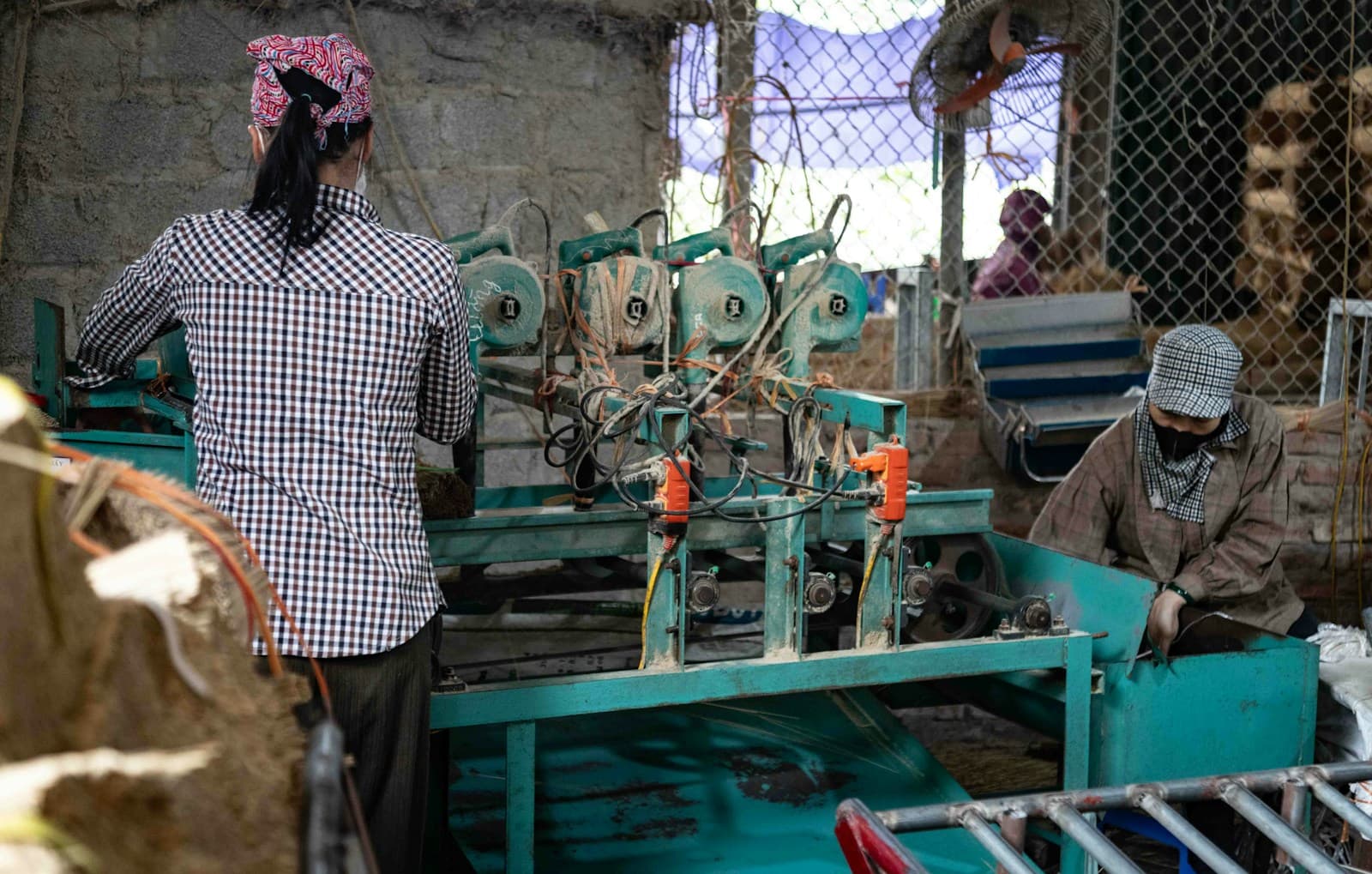 Factory operators working with industrial equipment on production floor